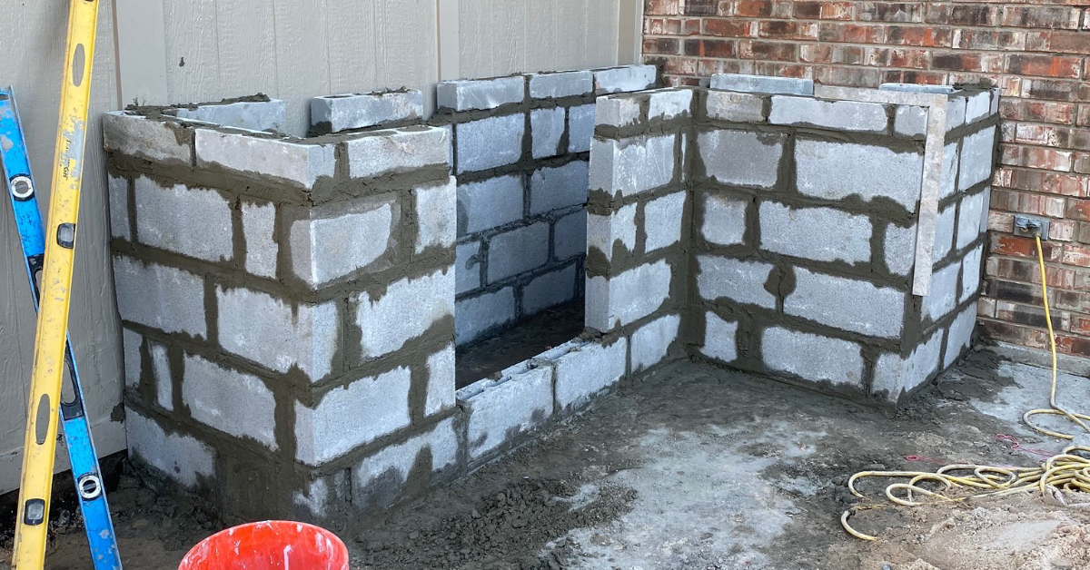 Picture of outdoor kitchen framework - cinderblocks with drying cement.